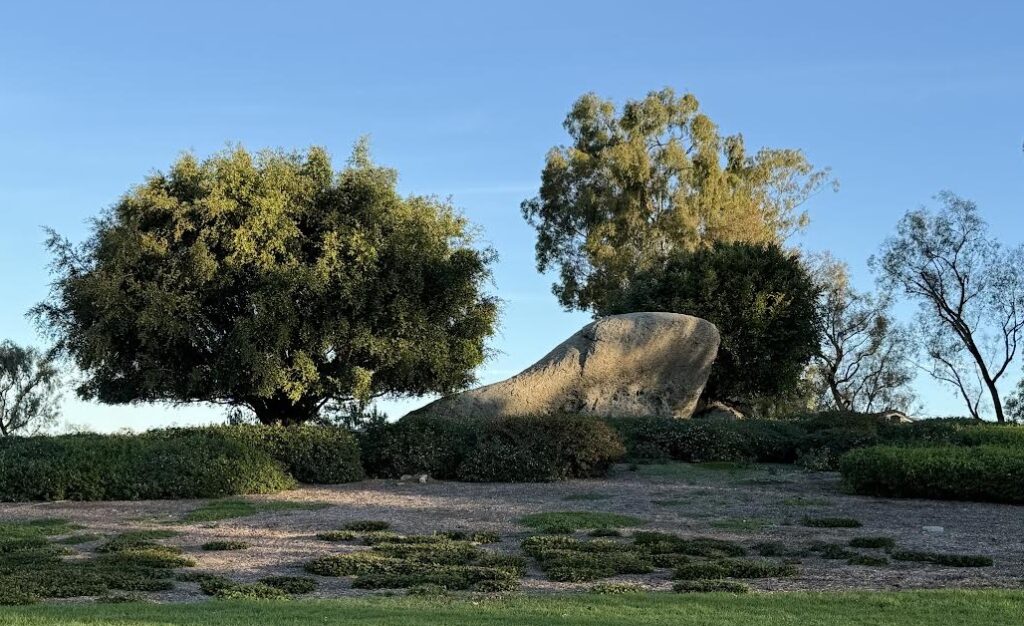 Turtle-shaped rock in the Turtle Rock neighborhood of Irvine with trees and greenbelt