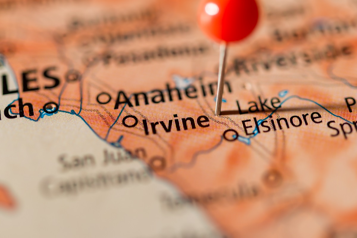 Map of Orange County with a red push pin marking Irvine, California — Irvine real estate market location