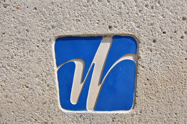 Woodbridge community entrance sign in Irvine, California featuring the signature blue and white W logo