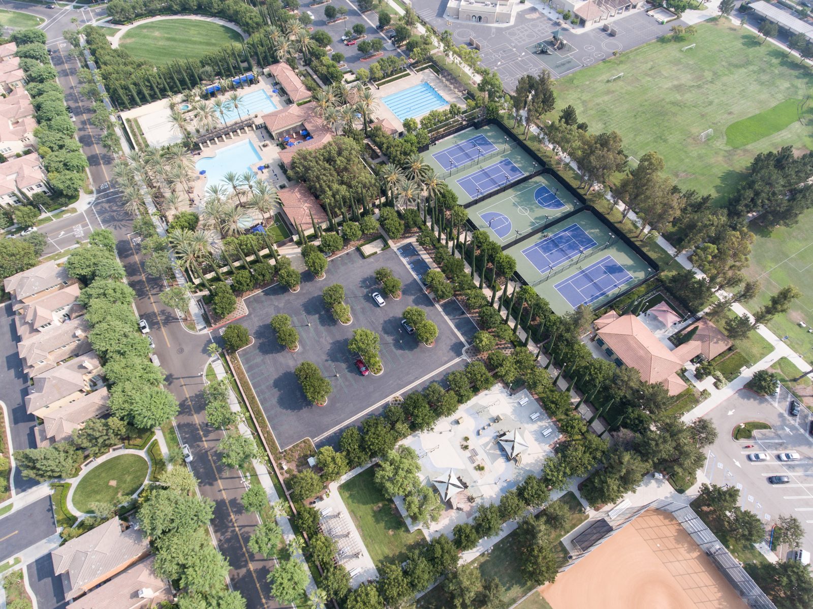 Aerial view of tennis courts, swimming pools and parks connected by internal walking paths in Woodbury, Irvine, California